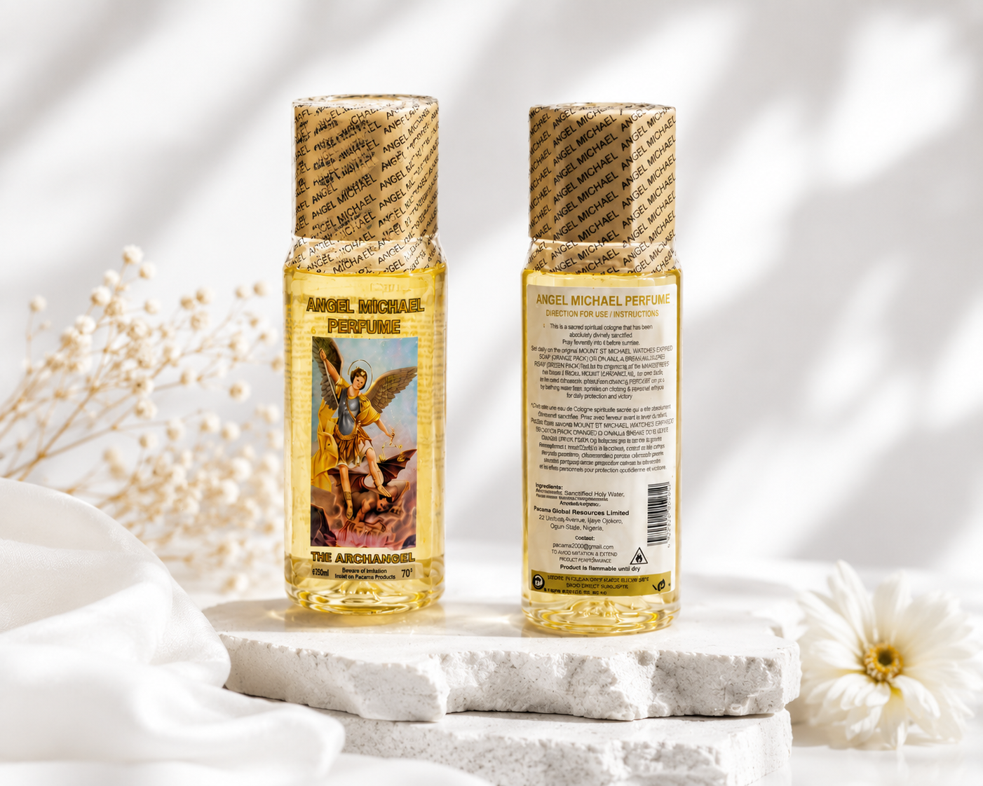 Two bottles of Angel Michael perfume on a light background with flowers.