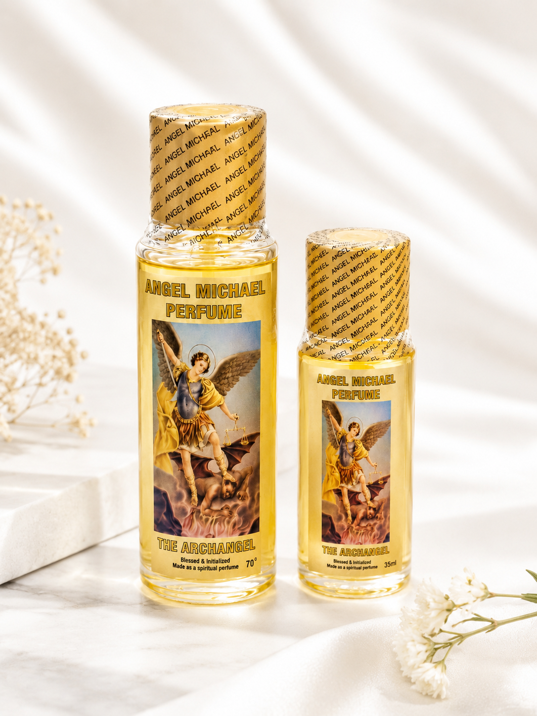 Two bottles of Angel Michael Perfume on a light background