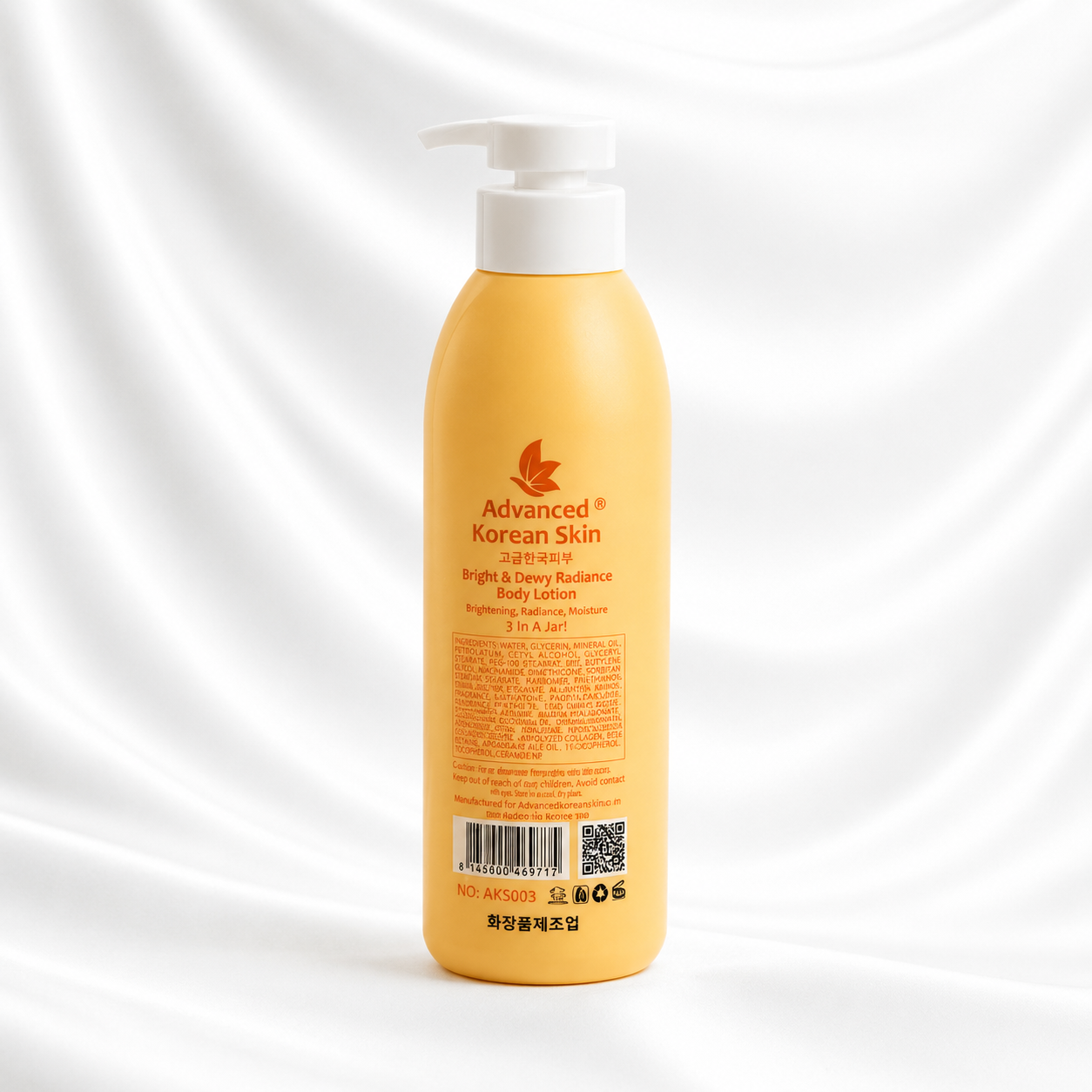 A bottle of Advanced Korean Skin Bright & Dewy Radiance Body Lotion in a warm yellow-orange color with a white pump dispenser, set against a draped white fabric background.