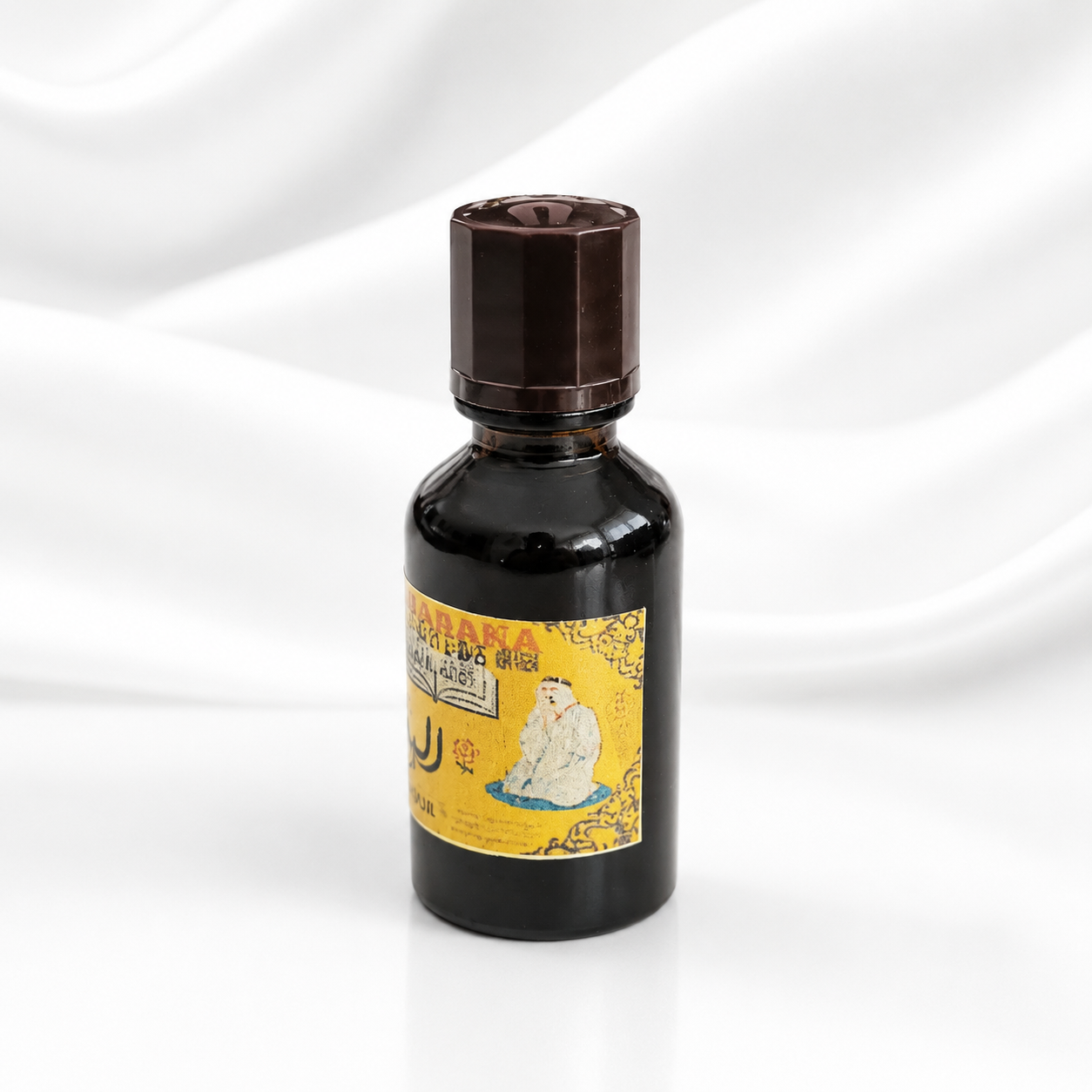 A small dark glass bottle with a brown cap and a yellow label featuring a polar bear illustration, set against a draped white fabric background.