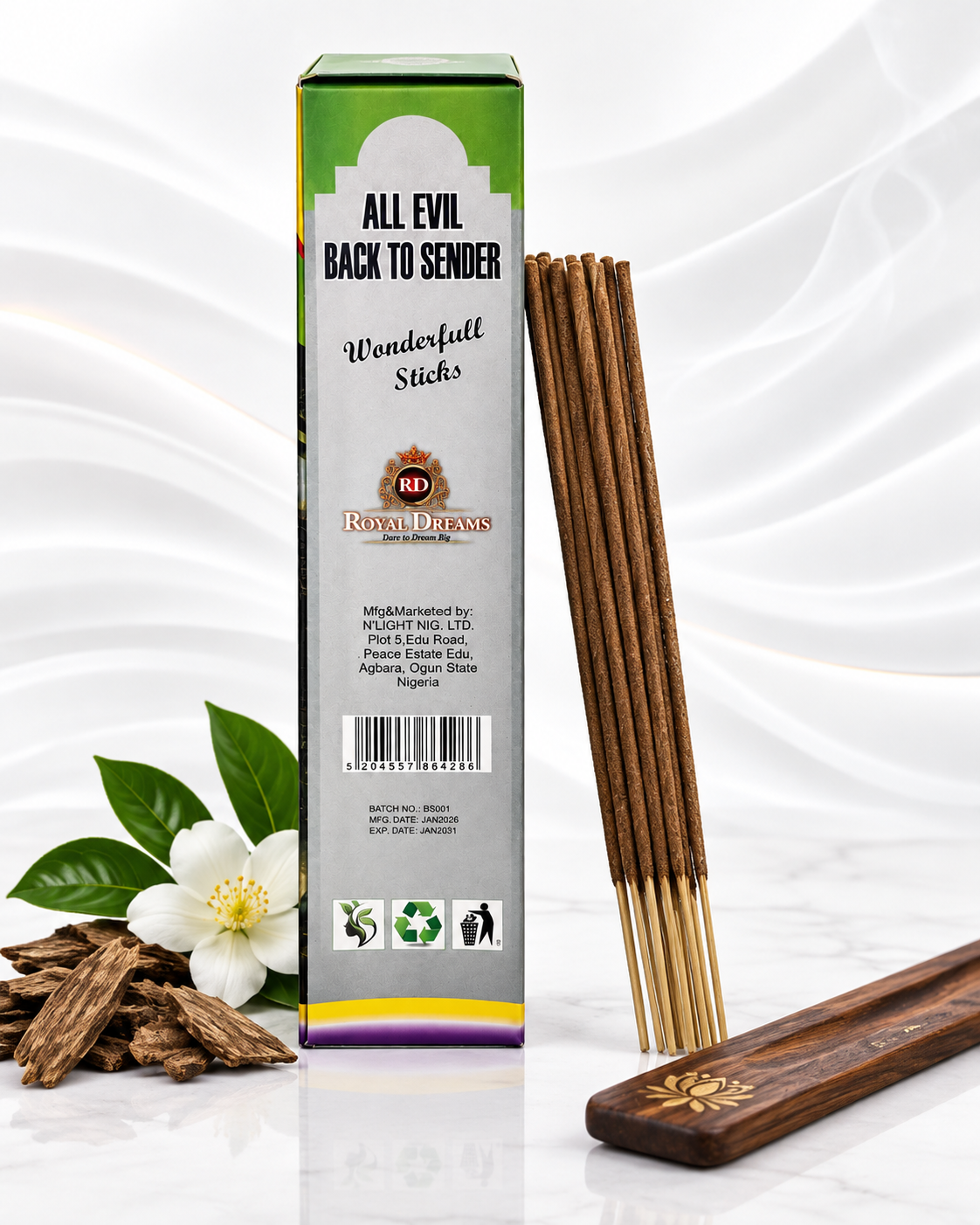 A box of Wonderfull Sticks incense sticks with several sticks standing upright, a wooden holder, a white flower, and wood pieces on a white draped background. The box reads 'ALL EVIL BACK TO SENDER' and 'Wonderfull Sticks' with a visible 'WD' mark.