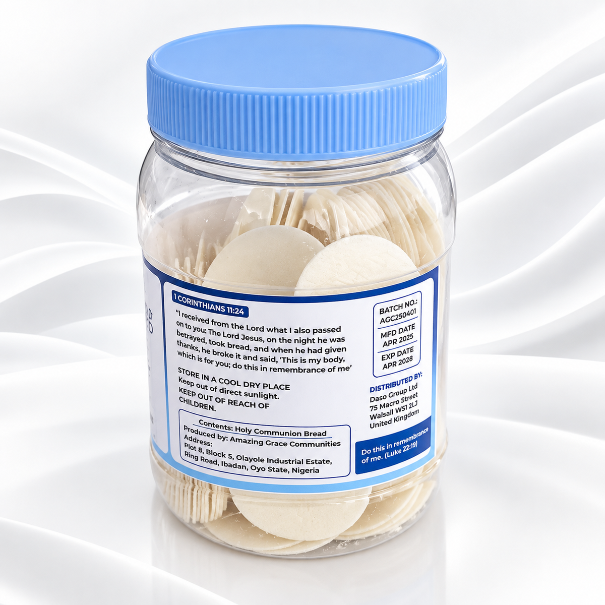 A clear plastic jar filled with sliced white bread rounds and topped with a blue screw-on lid, shown on a white background with soft wave graphics. The front label is mostly obscured, but the side label shows text including 'FOODSTAND 224' and 'BATCH NO: ACC2024'.