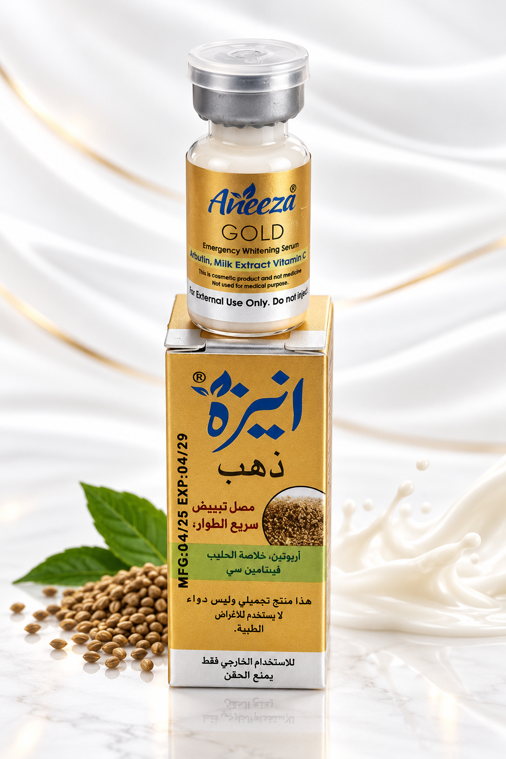 A small vial of Anceza Gold emergency revitalizing syrup standing on top of its matching rectangular box. The packaging is gold and white with Arabic text, and the scene is styled with milk splashes, a green leaf, and sesame seeds on a light marble-like surface.