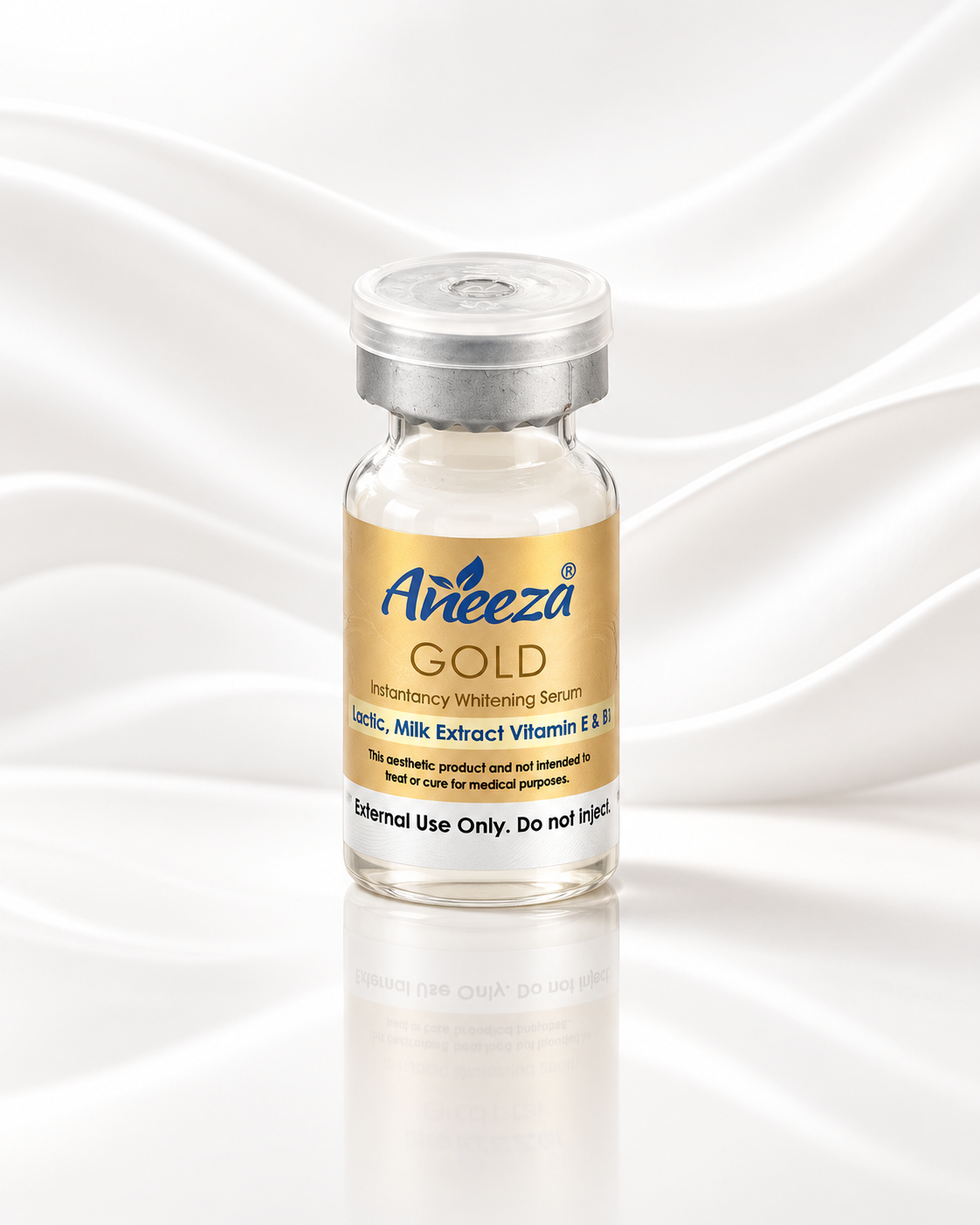 A small glass vial of Areeza Gold Intradermal Whiteing Serum with a gold label and silver cap, set against a white background with elegant draped fabric.