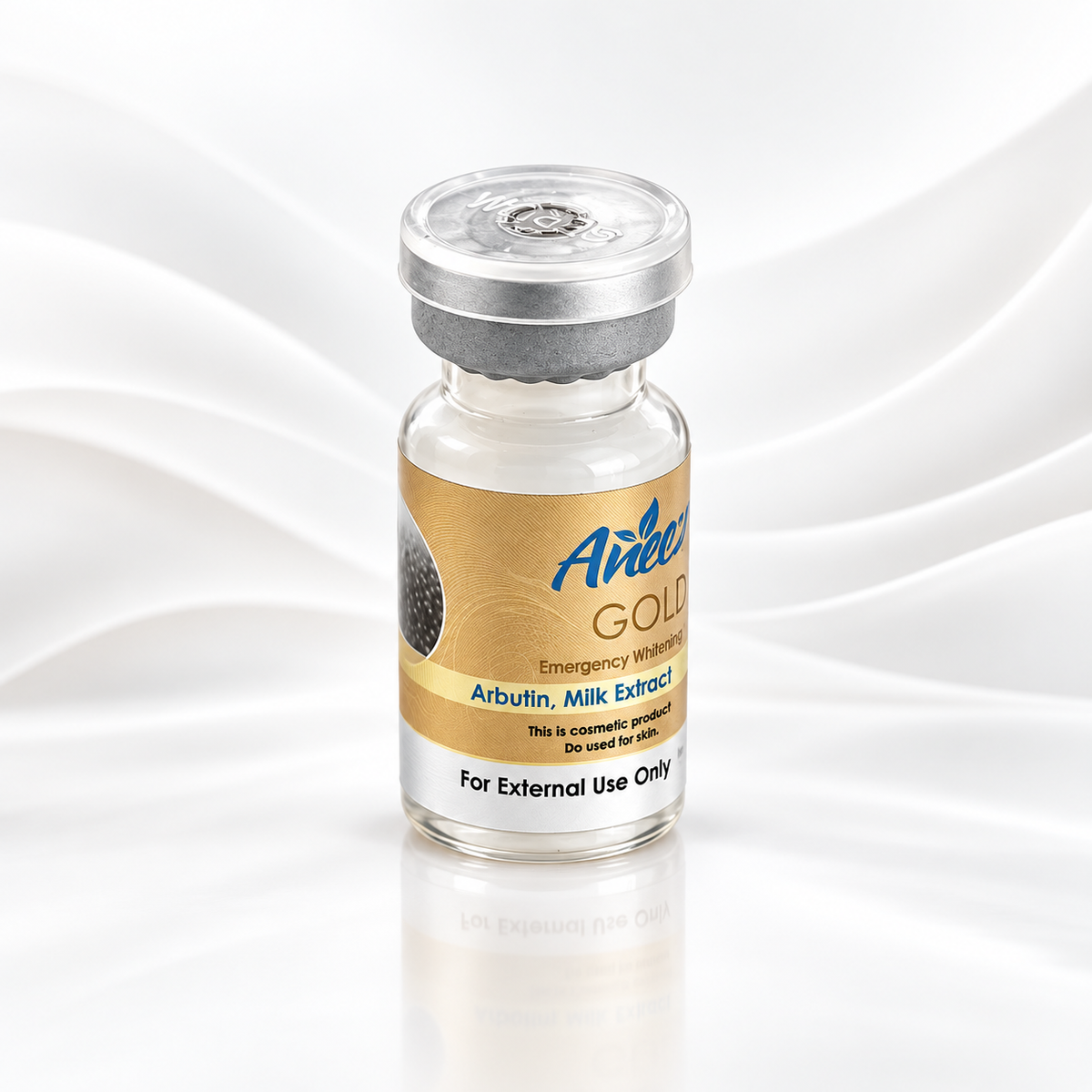 A small glass vial with a silver metal cap and a beige label reading 'Aineer Gold Emergency Whistle Arbinin, Milk Extract' on a white background with soft wave patterns.
