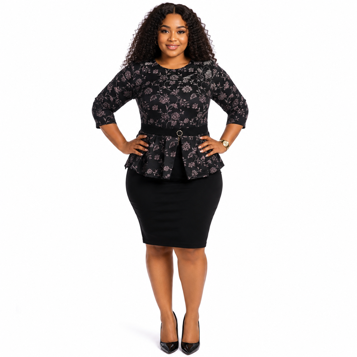 A woman modeling a black floral long-sleeve peplum top with a matching black pencil skirt, styled with black patent heels against a plain white background.