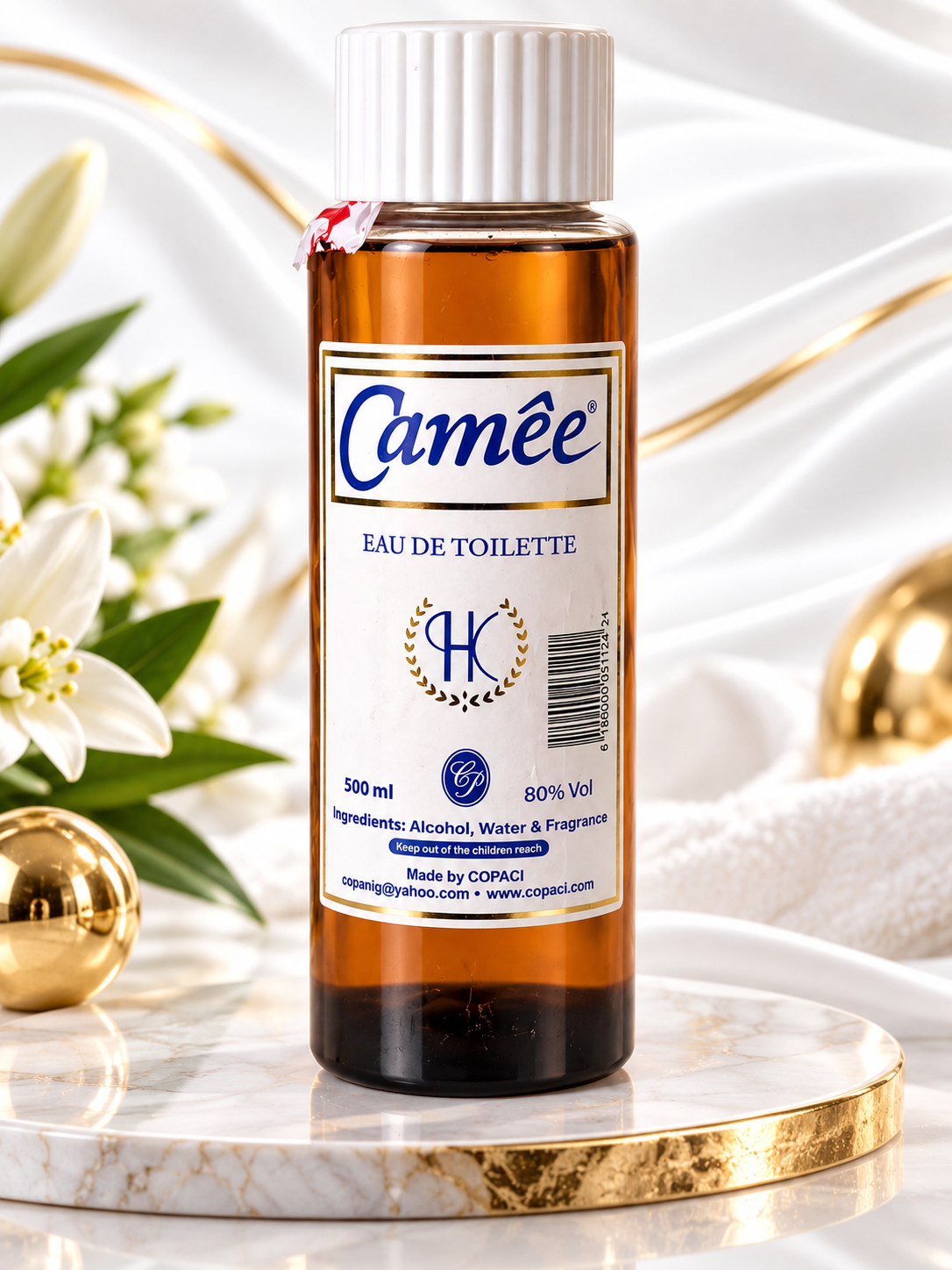 A 500 ml bottle of Camée Eau de Toilette fragrance oil by COPACI, displayed on a marble pedestal with gold trim. The bottle is amber brown with a white cap and a white label featuring blue text.