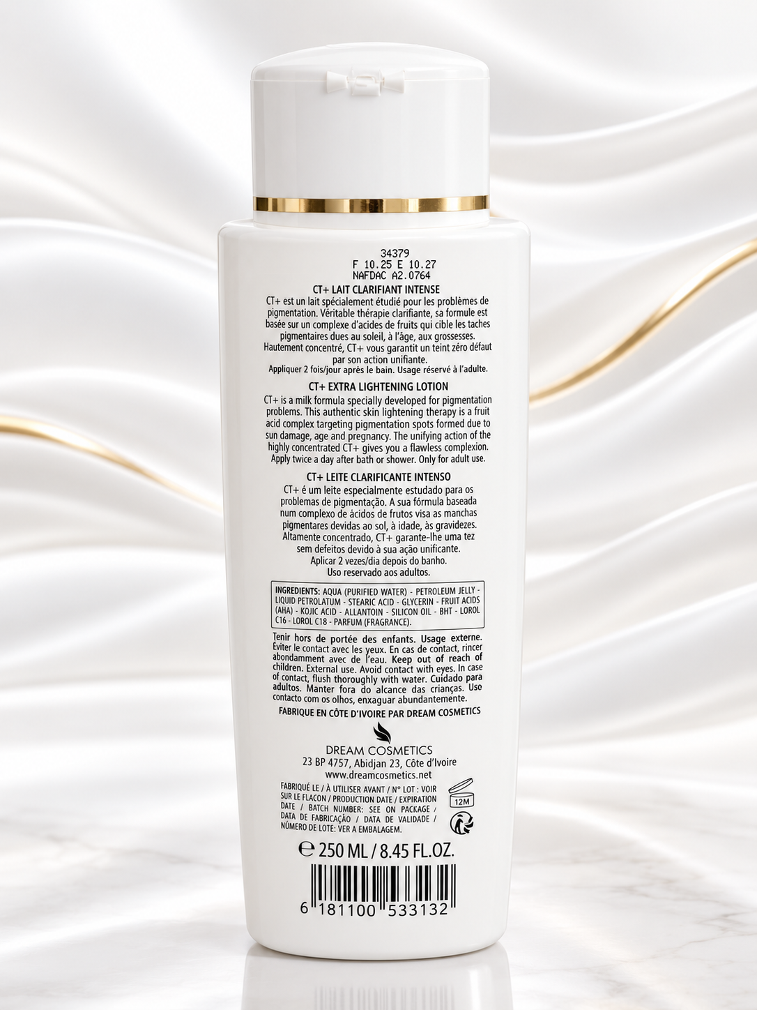 Back view of a white bottle of Dream Cosmetics Light Lumière Intense Extra Lighting Lotion with gold accents, set against a white satin background.