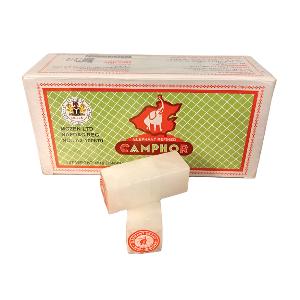 A box of Camphor ointment with a small white bar of ointment placed in front, on a plain white background.