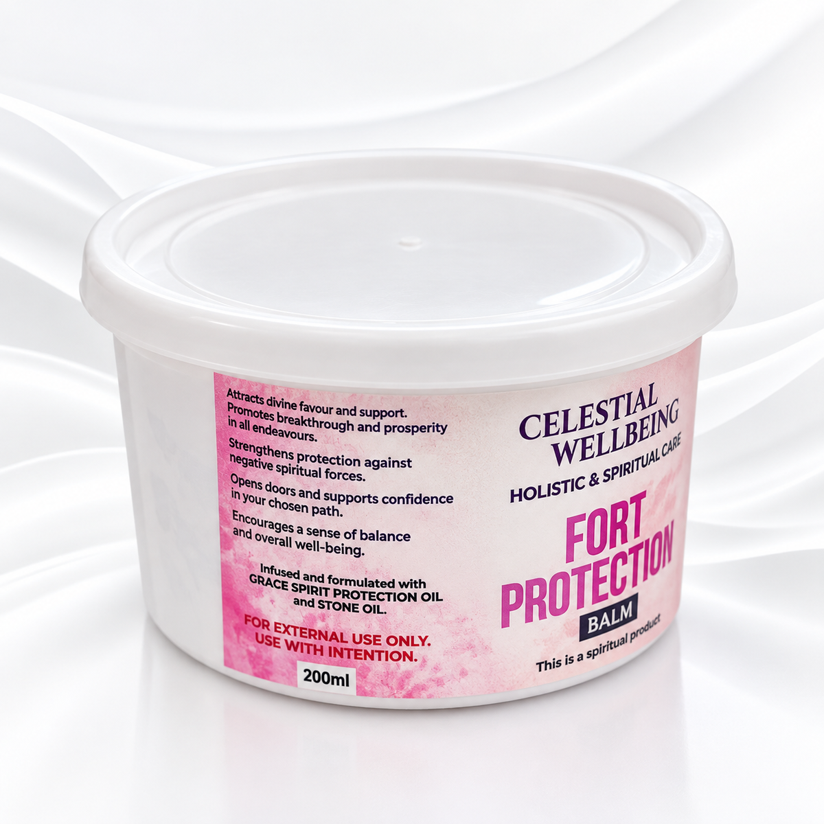 A 200ml white plastic tub of Celestial Wellbeing Fort Protection Balm, featuring a pink and purple label, set against a white draped satin background.