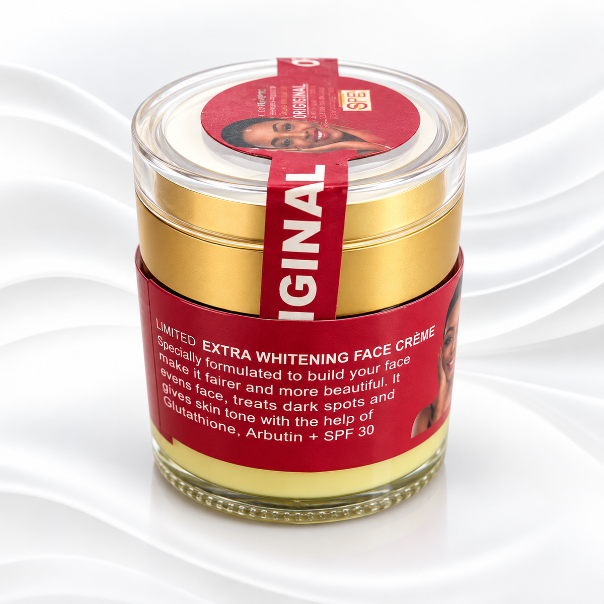 A jar of SKIN100 ORIGINAL Limited Extra Whitening Face Creme, featuring a gold-colored lid, a red label with white text, and a clear glass container showing the pale yellow cream inside, set against a white wavy background.