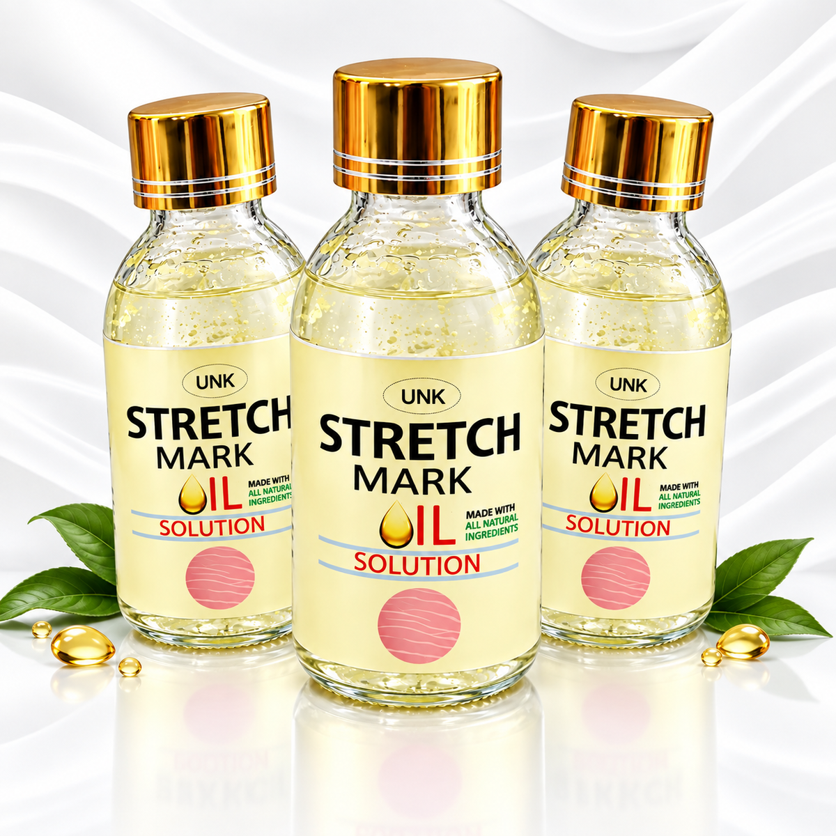 Three bottles of UNK Stretch Mark Oil Solution arranged together on a white reflective surface with decorative green leaves and gold capsules. The bottles are clear glass with pale yellow oil inside, gold caps, and cream-colored labels with black and red text.