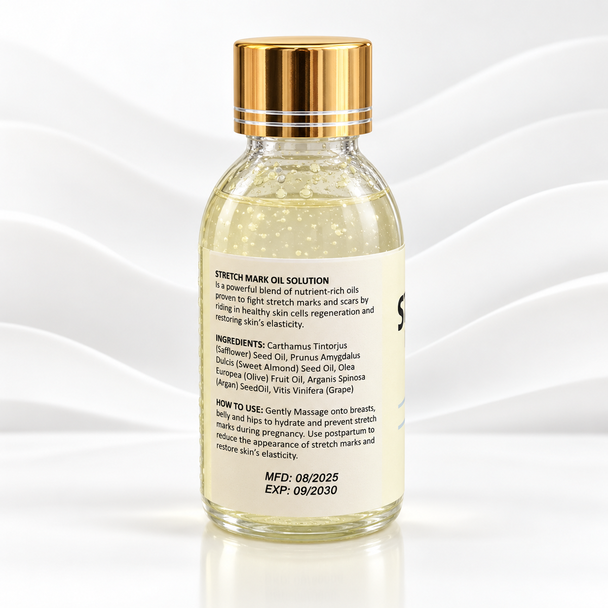 A glass bottle of Stretch Mark Oil Solution with a shiny gold cap, showing the back label with ingredients and usage instructions, set against a white background with elegant wave patterns.