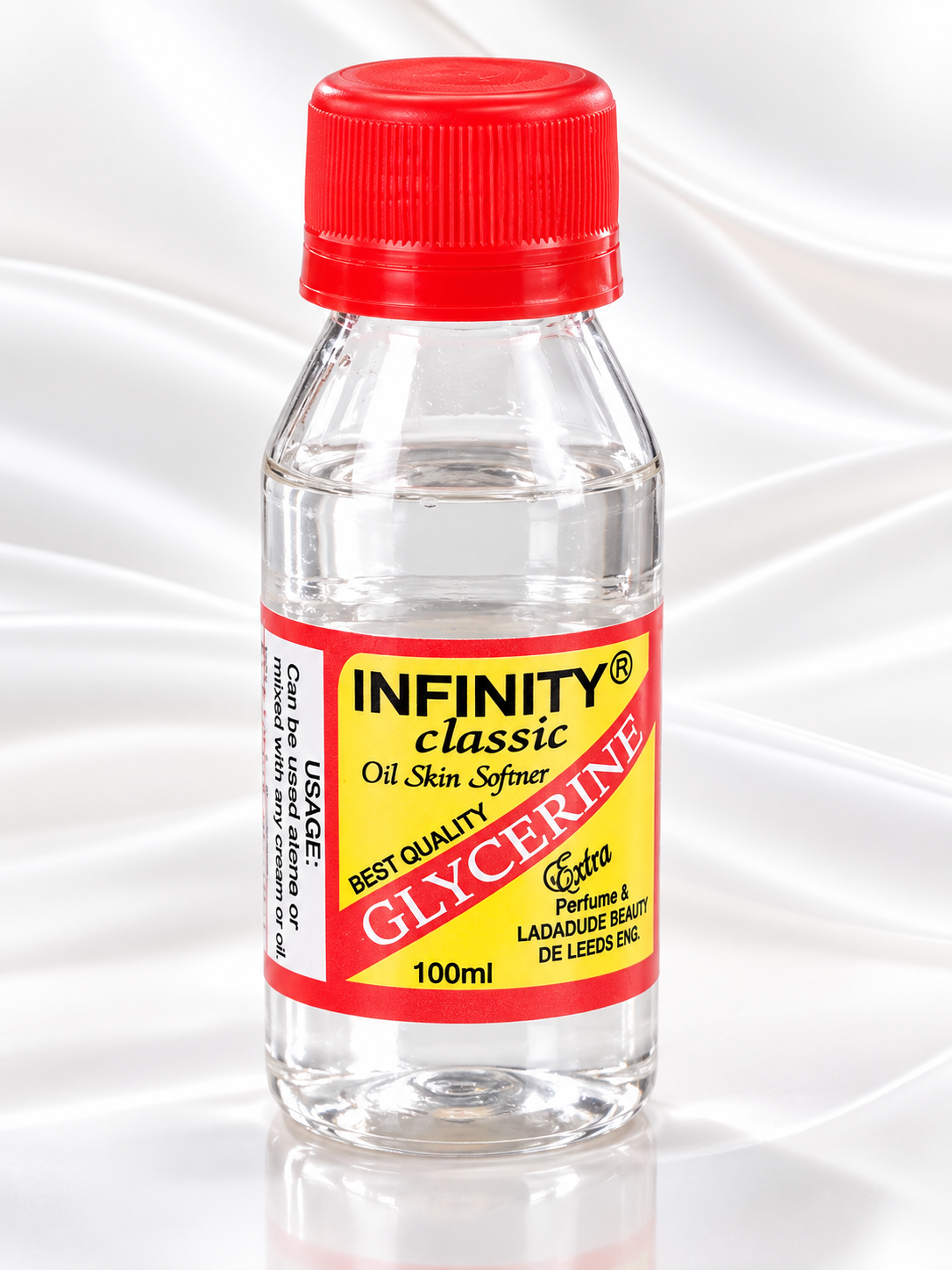 A 100ml bottle of Infinity Classic Glycerine Oil Skin Softener with a red cap and a red and yellow label, set against a white satin background.