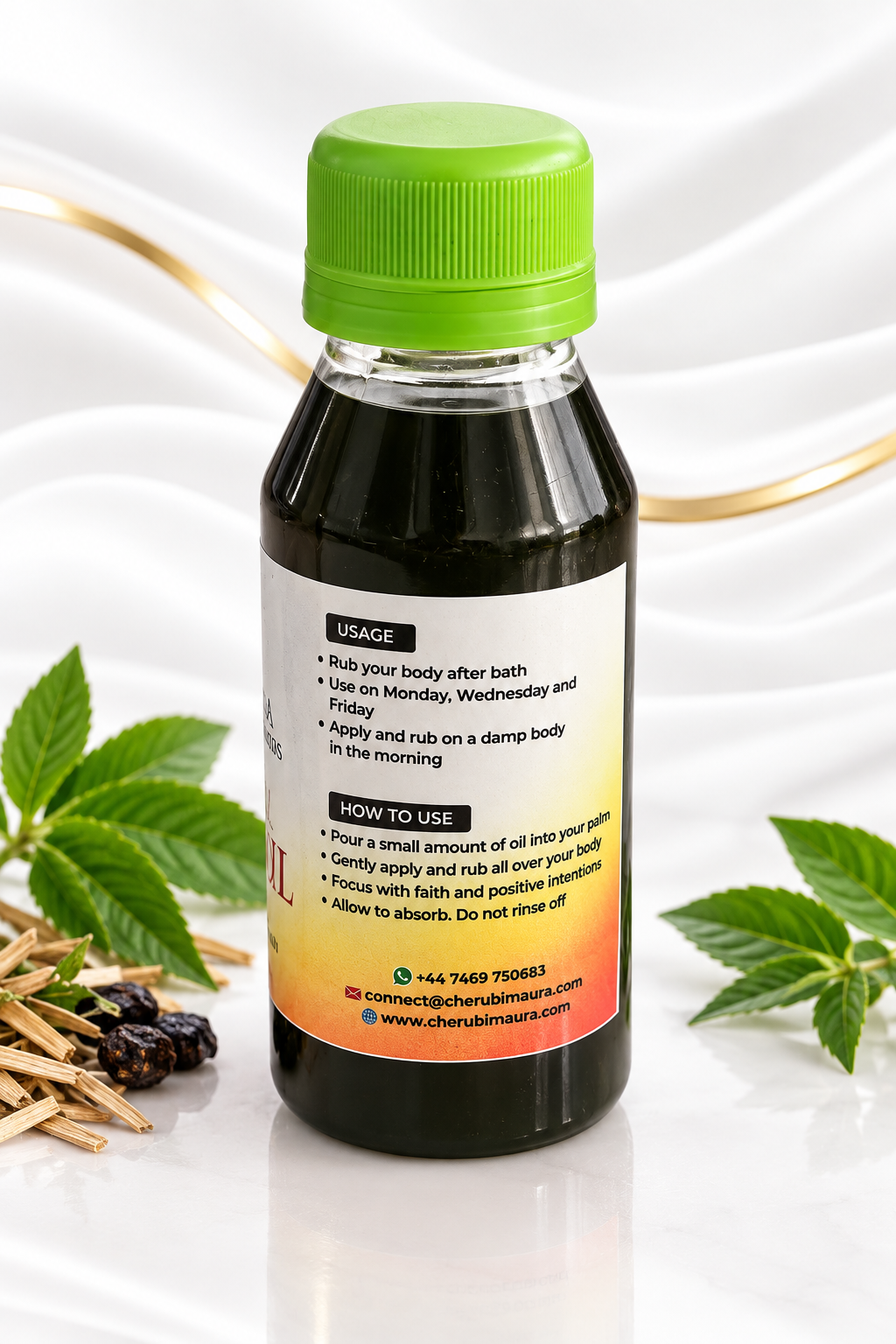 A bottle of herbal body oil with a bright green cap, shown on a white satin background with decorative mint leaves, cinnamon sticks, and dried berries. The back of the bottle features a white label with black text and a yellow-to-orange gradient at the bottom.