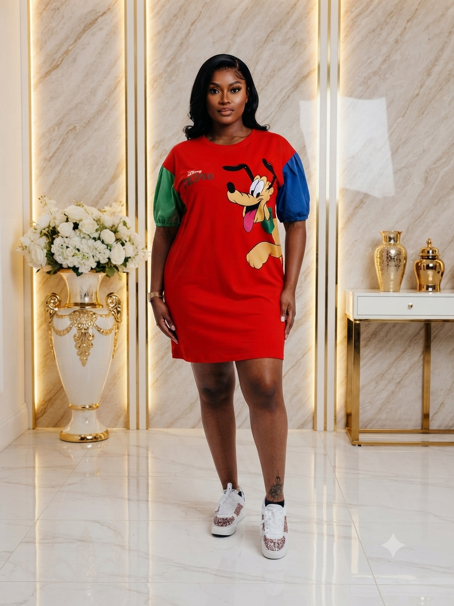 A woman modeling a red cartoon t-shirt dress with colorful green, blue, and yellow puff sleeves and a Goofy graphic, standing in a luxury marble hallway.