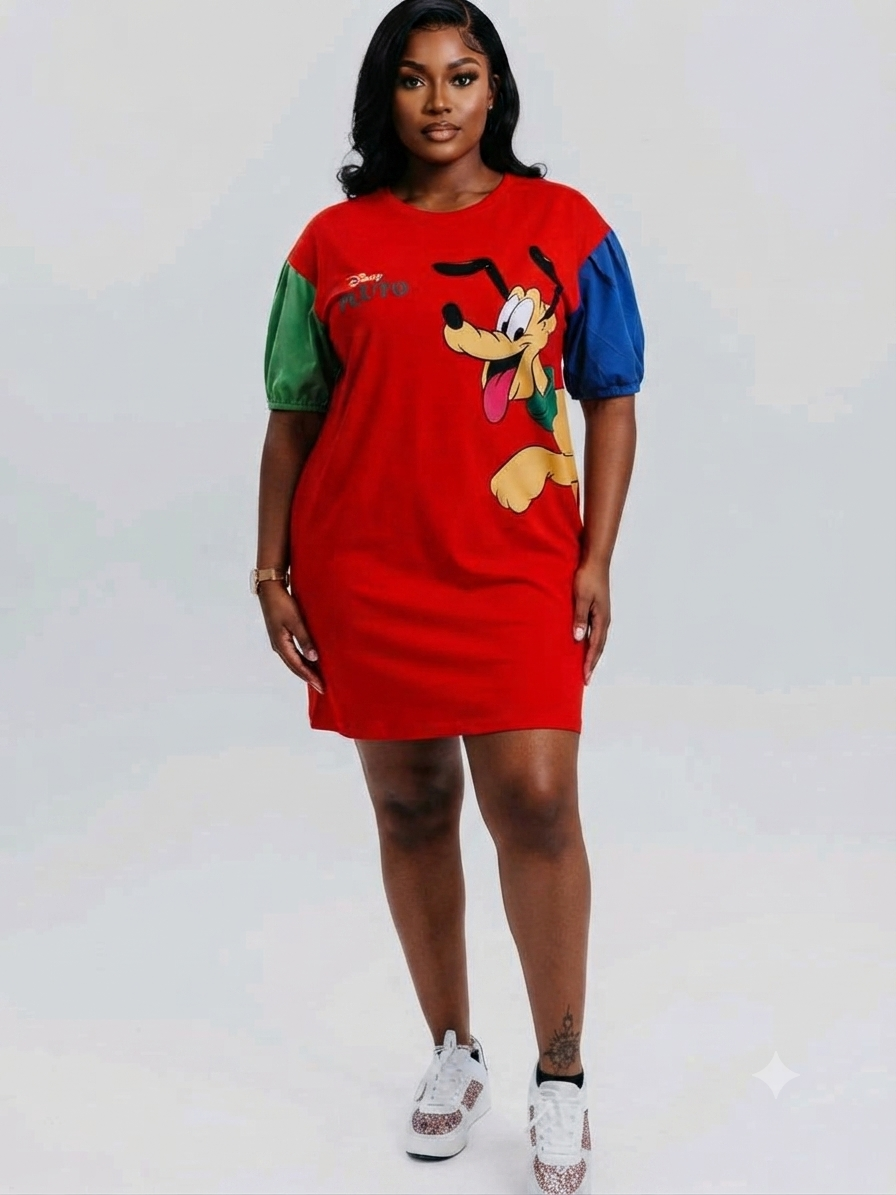 A woman modeling a red short-sleeve dress with color-blocked green and blue sleeves and a large cartoon dog graphic on the front, paired with white sneakers, against a light gray studio background.