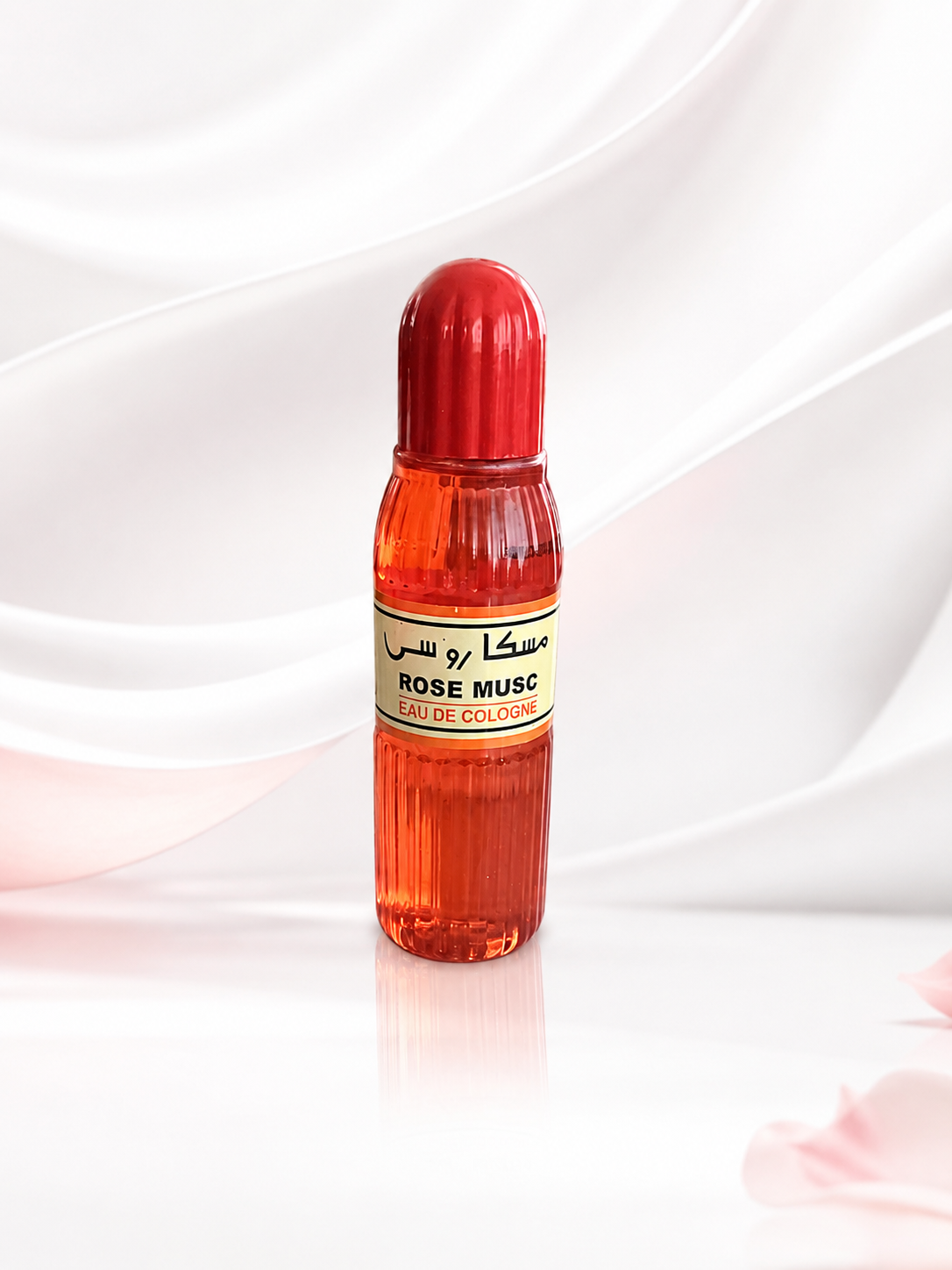 A small cylindrical bottle of Rose Musc fragrance oil with a red cap and a cream label, set against a soft white draped fabric background.