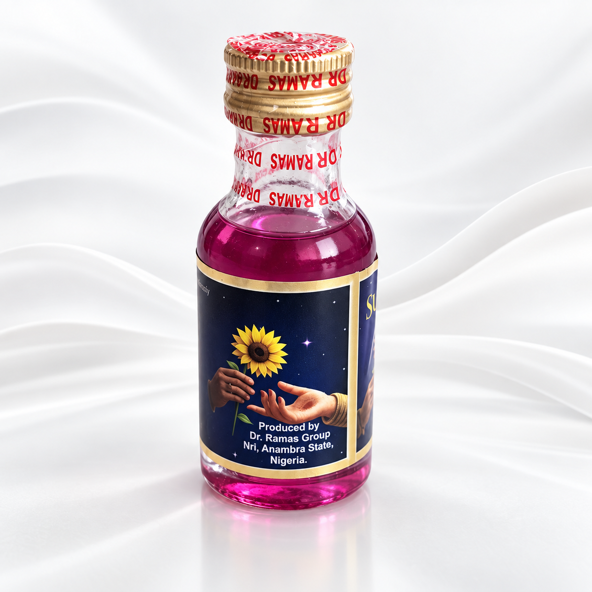 A small glass bottle of Dr. Ramas Deva Ayurvedic oil, filled with a vibrant magenta-pink liquid, featuring a gold cap and a label with a sunflower illustration and text, set against a white draped fabric background.