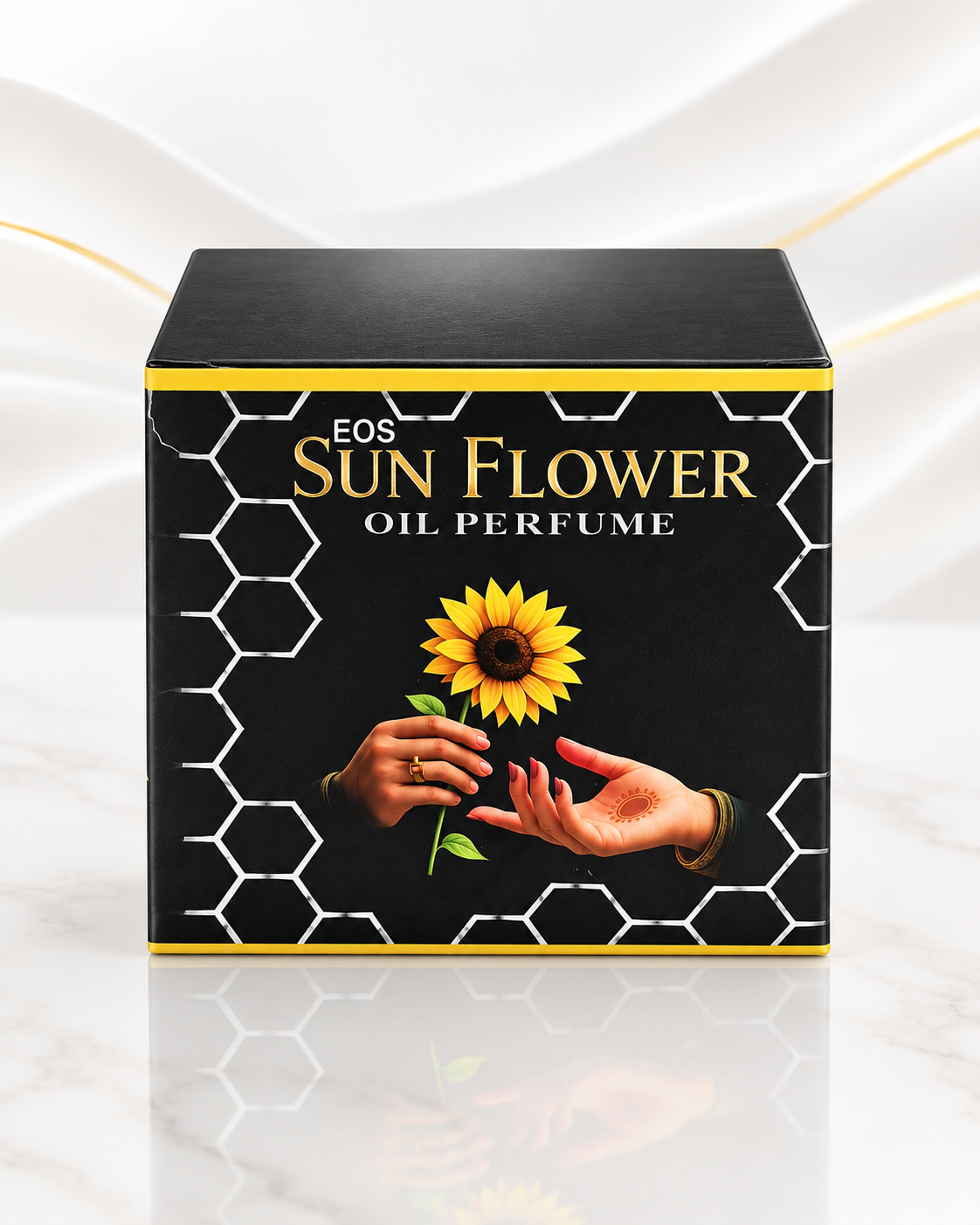 A square black box of EOS Sun Flower Oil Perfume, featuring a yellow sunflower and hands graphic on the front, set against a white marble background with soft gold leaf accents.