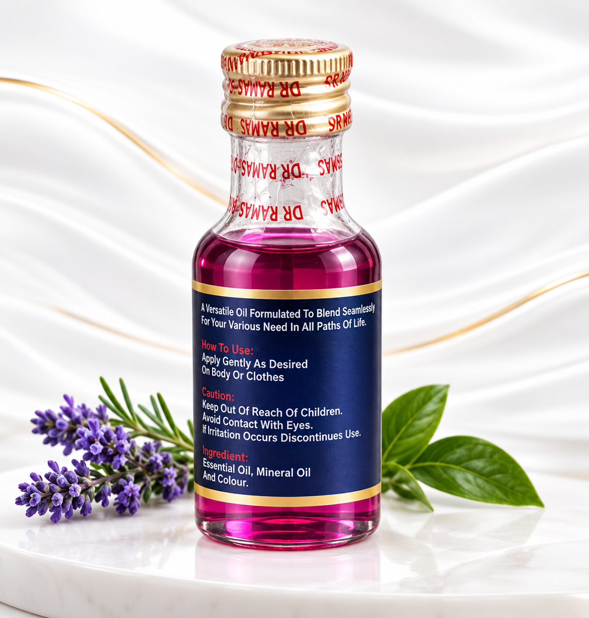 A small glass bottle of Dr. Ramdas Devotional Oil with a gold cap and navy blue label, filled with pink liquid, displayed on a white marble surface with decorative lavender and green leaves.