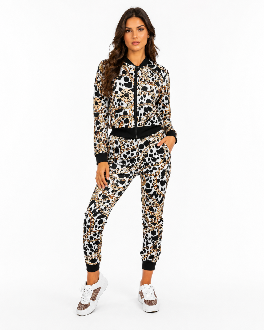 A woman modeling a matching two-piece leopard print tracksuit with a zip-up hoodie and jogger pants, featuring black cuffs, hem, and a black waistband, paired with white sneakers against a plain white background.