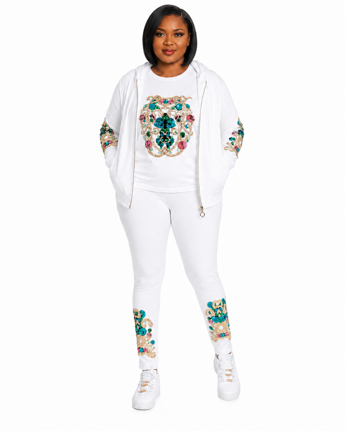 A woman modeling a white three-piece tracksuit featuring a zip-up hoodie, t-shirt, and leggings, all decorated with colorful floral and geometric patterns on the chest and lower legs, paired with white sneakers against a plain white background.