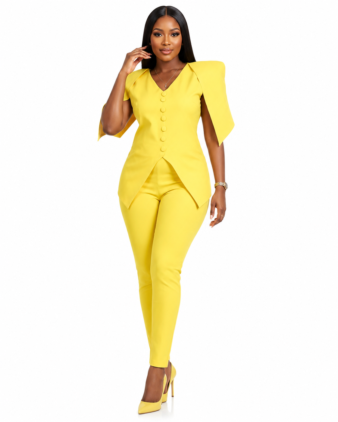 A woman modeling a bright yellow two-piece suit featuring a short-sleeve button-front top with dramatic shoulder panels and matching slim-fit pants, paired with yellow high heels on a plain white background.